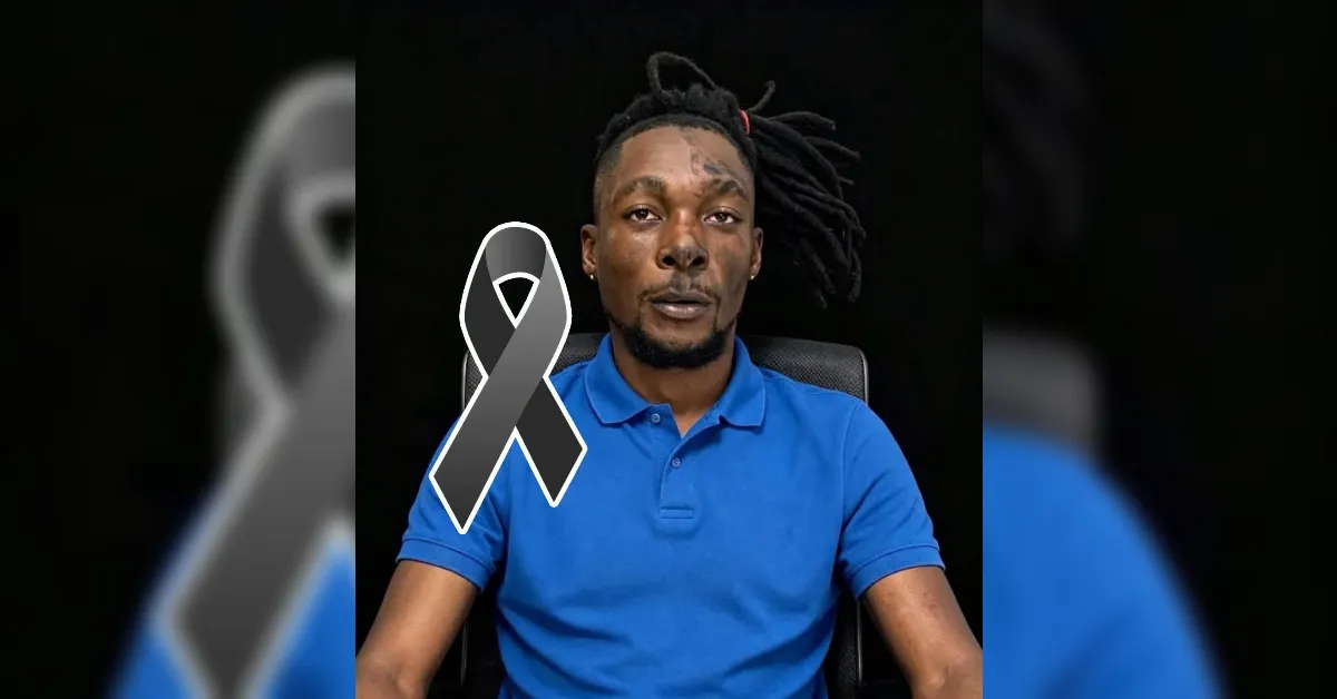 Portrait of a man in a blue polo shirt seated against a black background, with a large gray awareness ribbon overlay indicating remembrance or support.