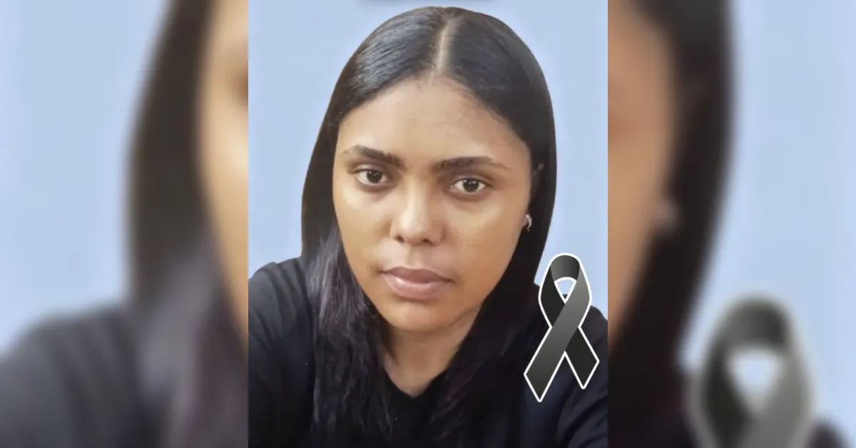 Portrait of a woman with straight black hair wearing a black shirt, against a blue background, with a black awareness ribbon overlay signaling mourning or solidarity.