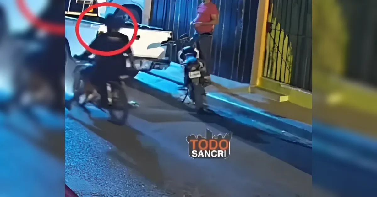 Nighttime street scene with a person on a motorcycle near a blue storefront; a second figure stands nearby, circled in red to indicate a suspect.
