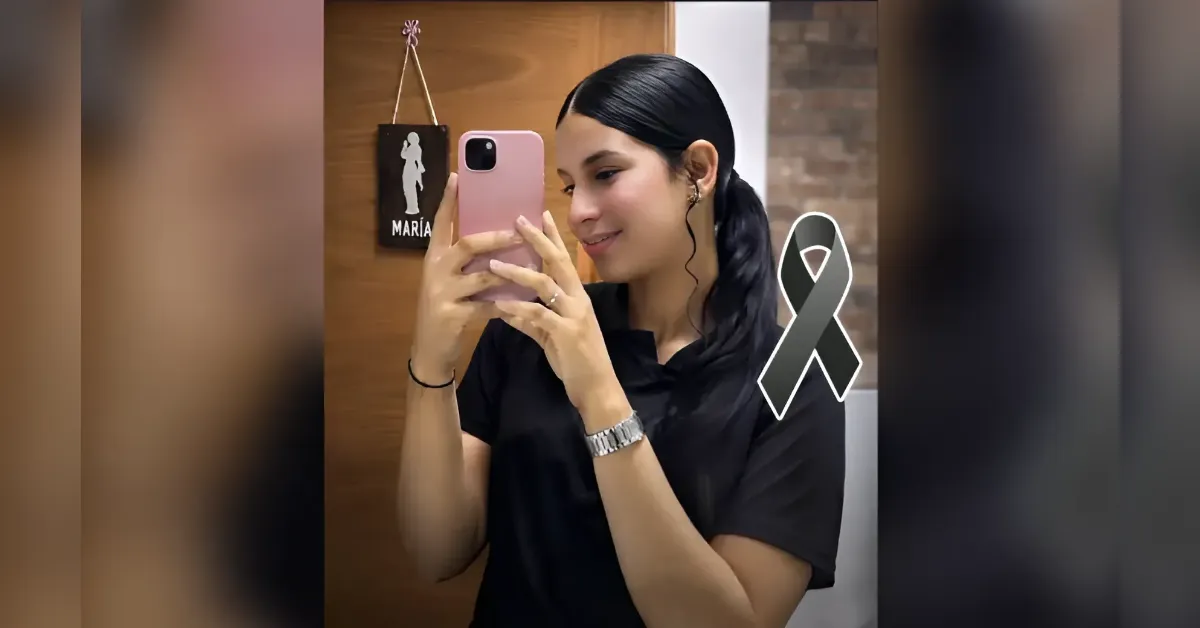 Young woman takes a mirror selfie with a pink phone, wearing a black shirt and silver watch, a gray awareness ribbon beside her