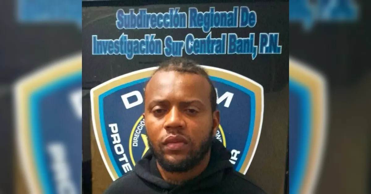 Portrait of a man in a black hoodie posed in front of a police shield with the Subdirección Regional De Investigación Sur Central branding visible above the logo.