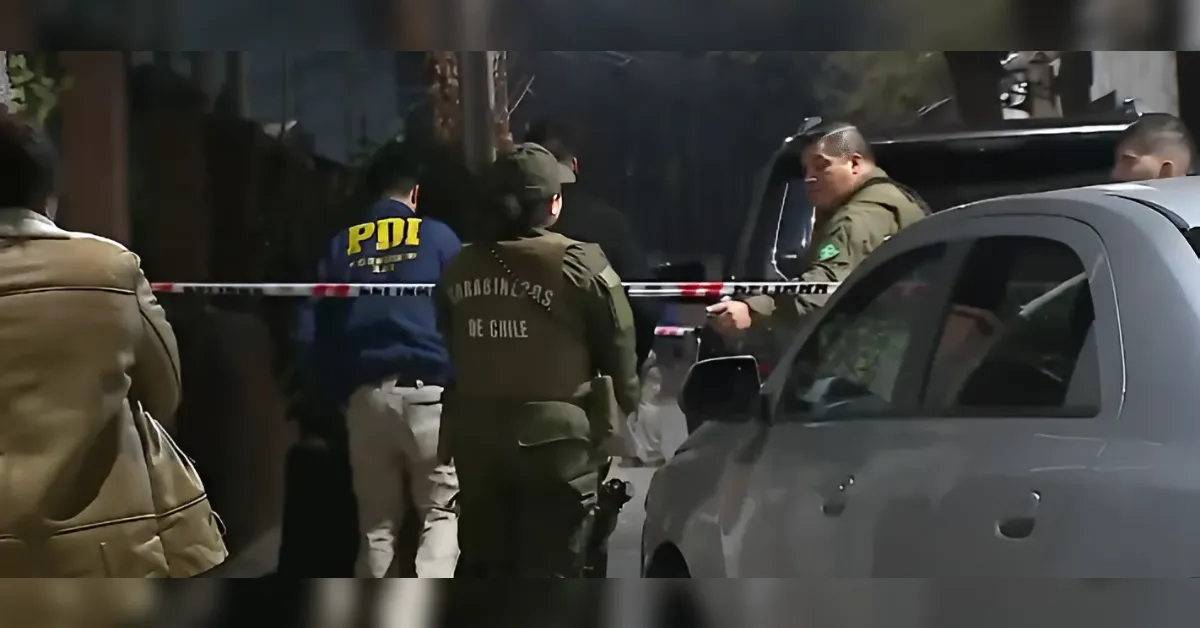 Carabineros de Chile police secure a street crime scene behind red tape, with a gray car in the foreground.