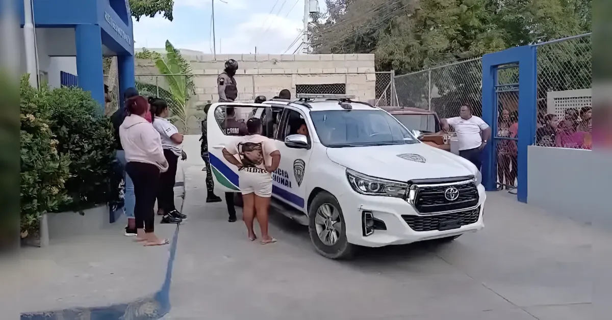 White municipal police SUV with blue and green graphics parked outside a gated area as officers and civilians stand nearby.