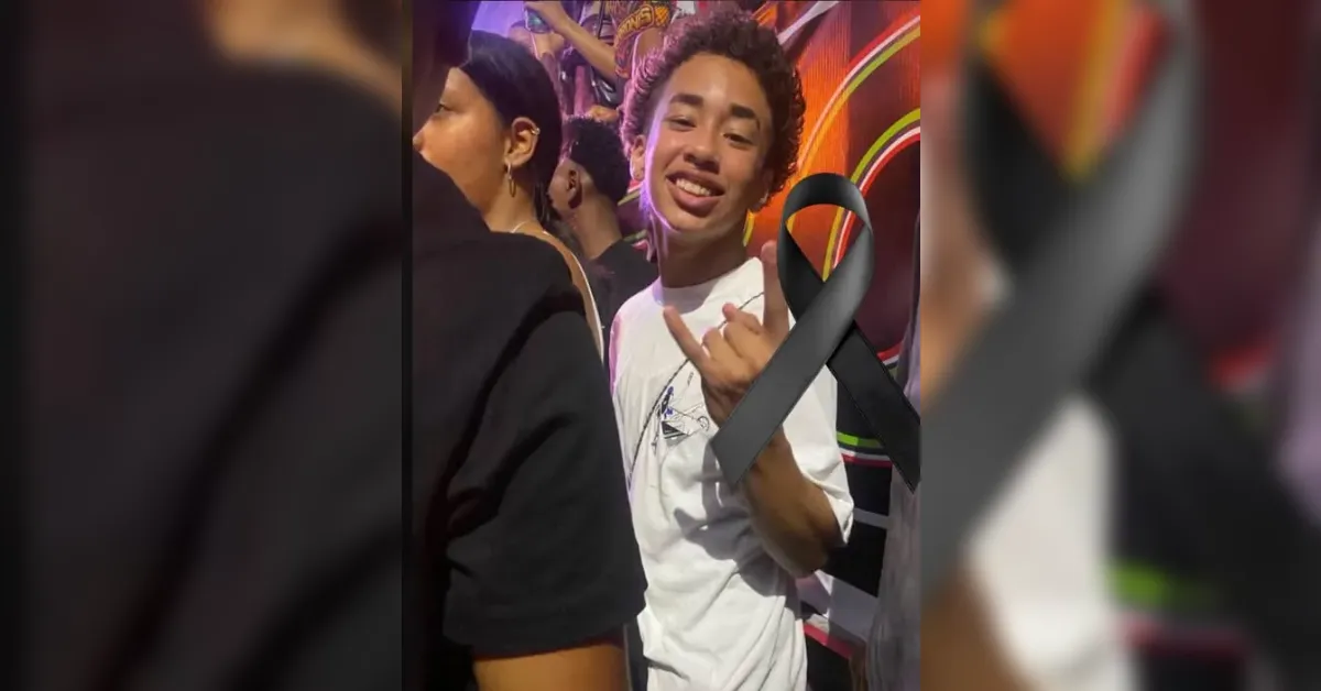 Smiling young person in a white shirt at a crowded event, flashing the rock-on gesture; a large black awareness ribbon overlays the image.