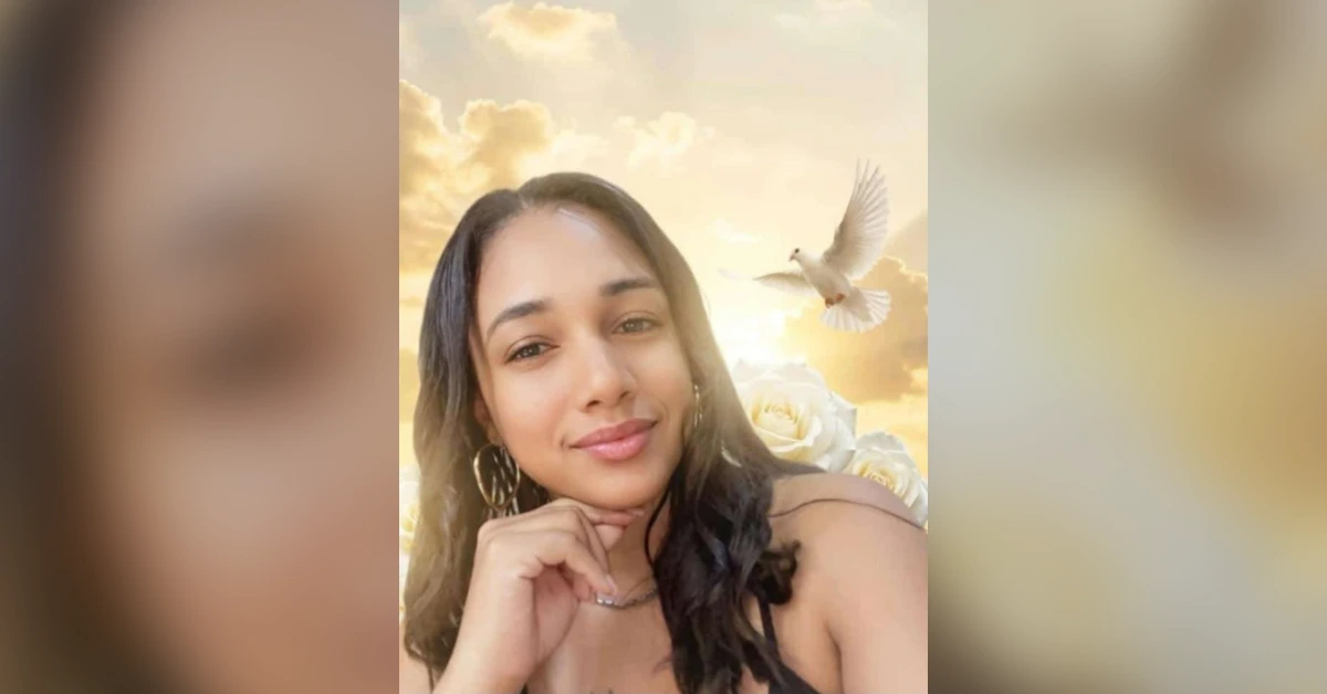 Portrait of a smiling woman posing for a selfie, hand under her chin, with white roses and a white dove in a golden sunset sky behind her.