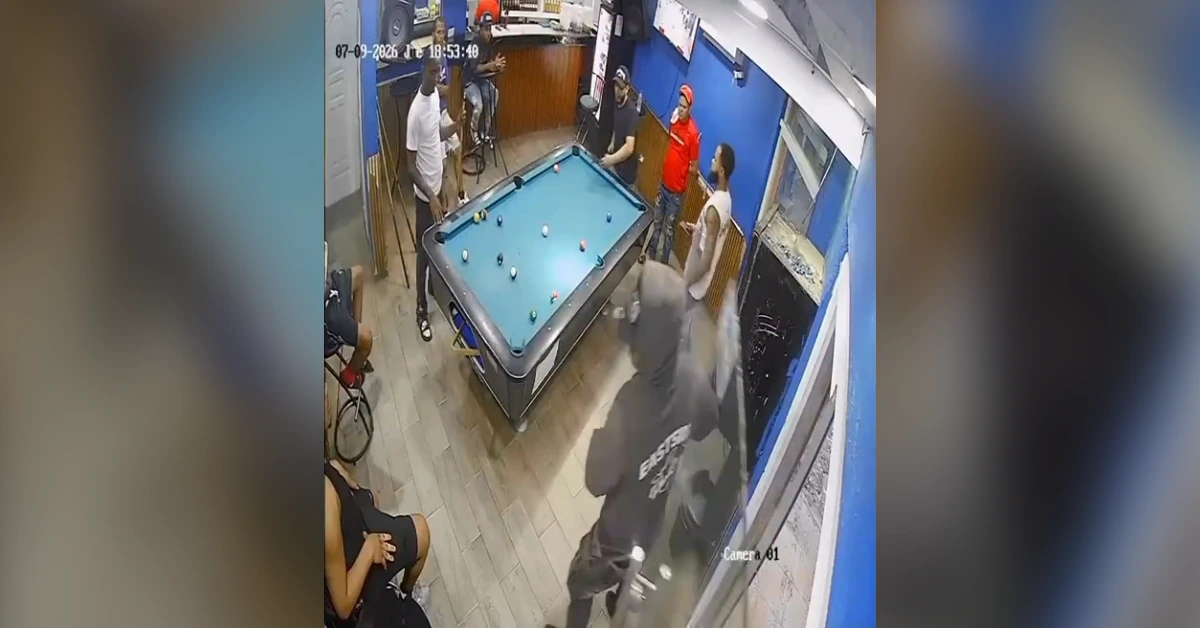Surveillance still of a group of men around a pool table in a blue-walled room, with one man in white at the table and others nearby (timestamp visible).