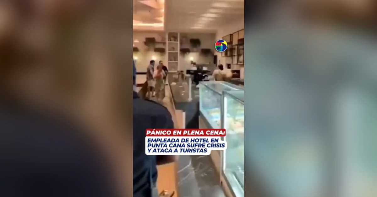 Caos en un restaurante de hotel: varias personas de pie y en movimiento, con un rótulo de noticias superpuesto en la escena.