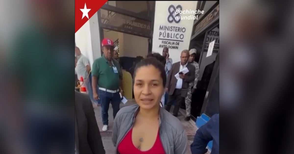 Woman in red top speaks to camera outside a public ministry building; people and security present in the background; 'Ministerio Publico' sign visible behind.