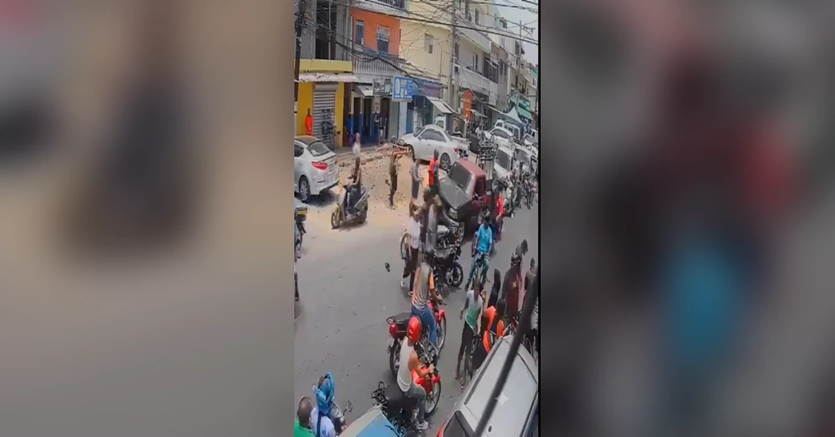 Crowded urban street with many motorcycles and pedestrians gathered around a central event.