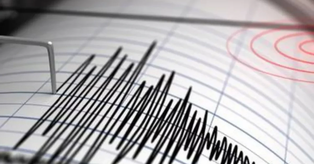 Seismograph recording with jagged black seismic spikes on paper, red target marks in the background.