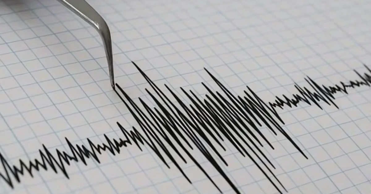 Close-up of a jagged waveform tracing on graph paper with a metal instrument nearby, suggesting a medical readout like an ECG/recording.