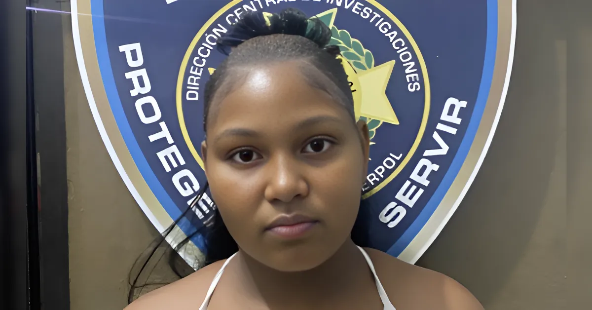 Portrait of a young woman in front of a circular police seal backdrop.