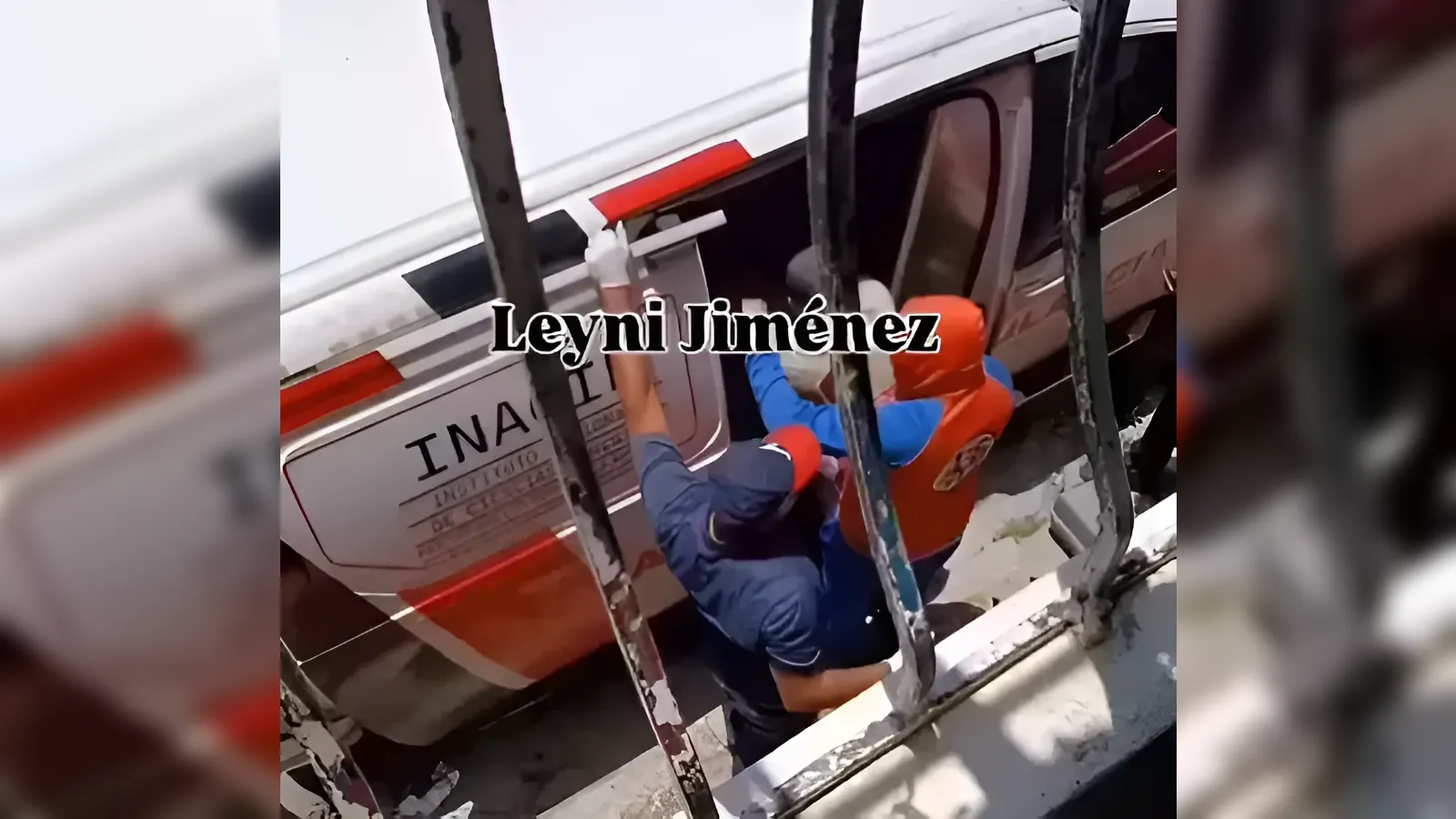 Two responders in blue and orange gear assist a person inside a damaged bus, seen through window bars, with the caption 'Leyni Jiménez' across the screen.