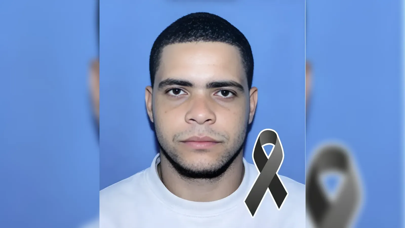 Portrait of a young man with short dark hair against a blue backdrop, wearing a white shirt, with a black mourning ribbon overlay suggesting tribute or remembrance.