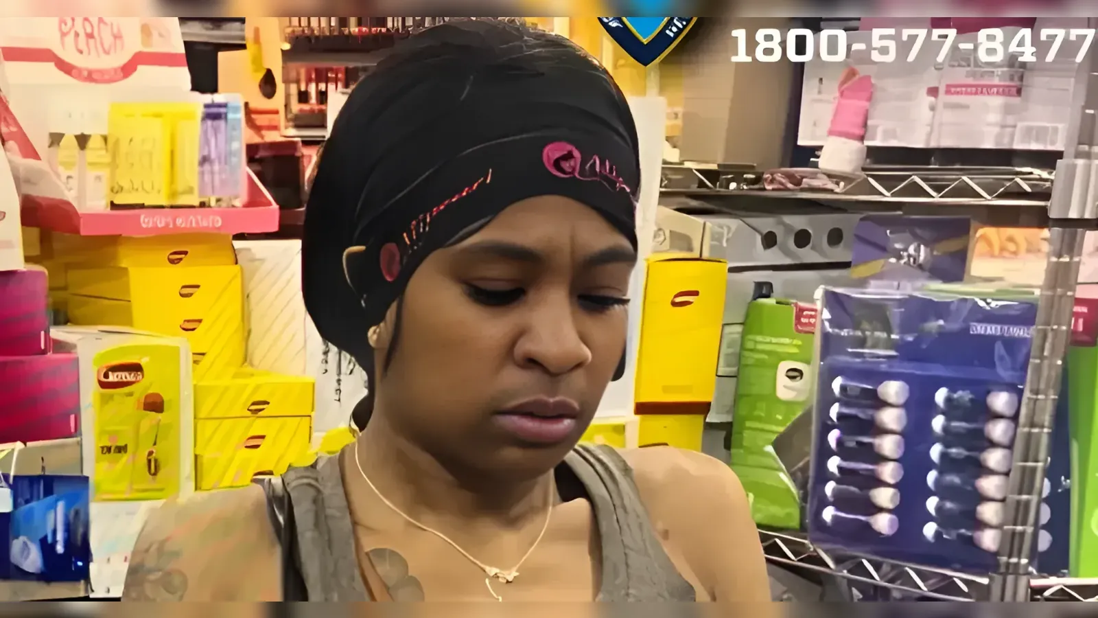 Woman wearing a black headwrap browses in a beauty supply store, surrounded by colorful product boxes on shelves.