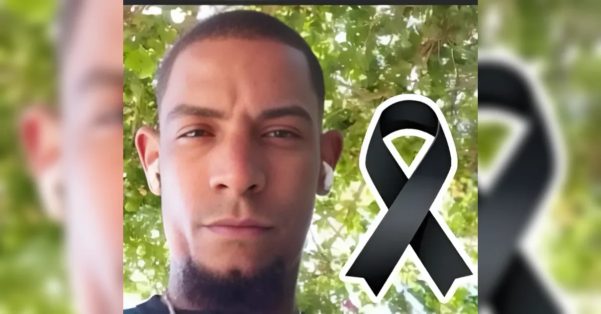 Close-up portrait of a man outdoors with a black remembrance ribbon overlay.
