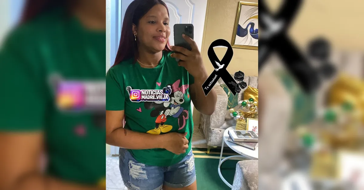 Woman in a green Mickey Mouse T‑shirt takes a mirror selfie in a living room, holding a phone up to snap the photo.