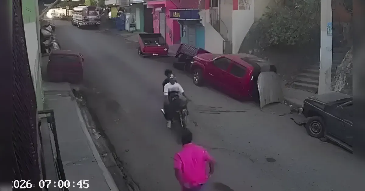Surveillance street scene: a pink-shirt man runs toward the camera as a motorcyclist follows; a red car is tipped onto the curb nearby.