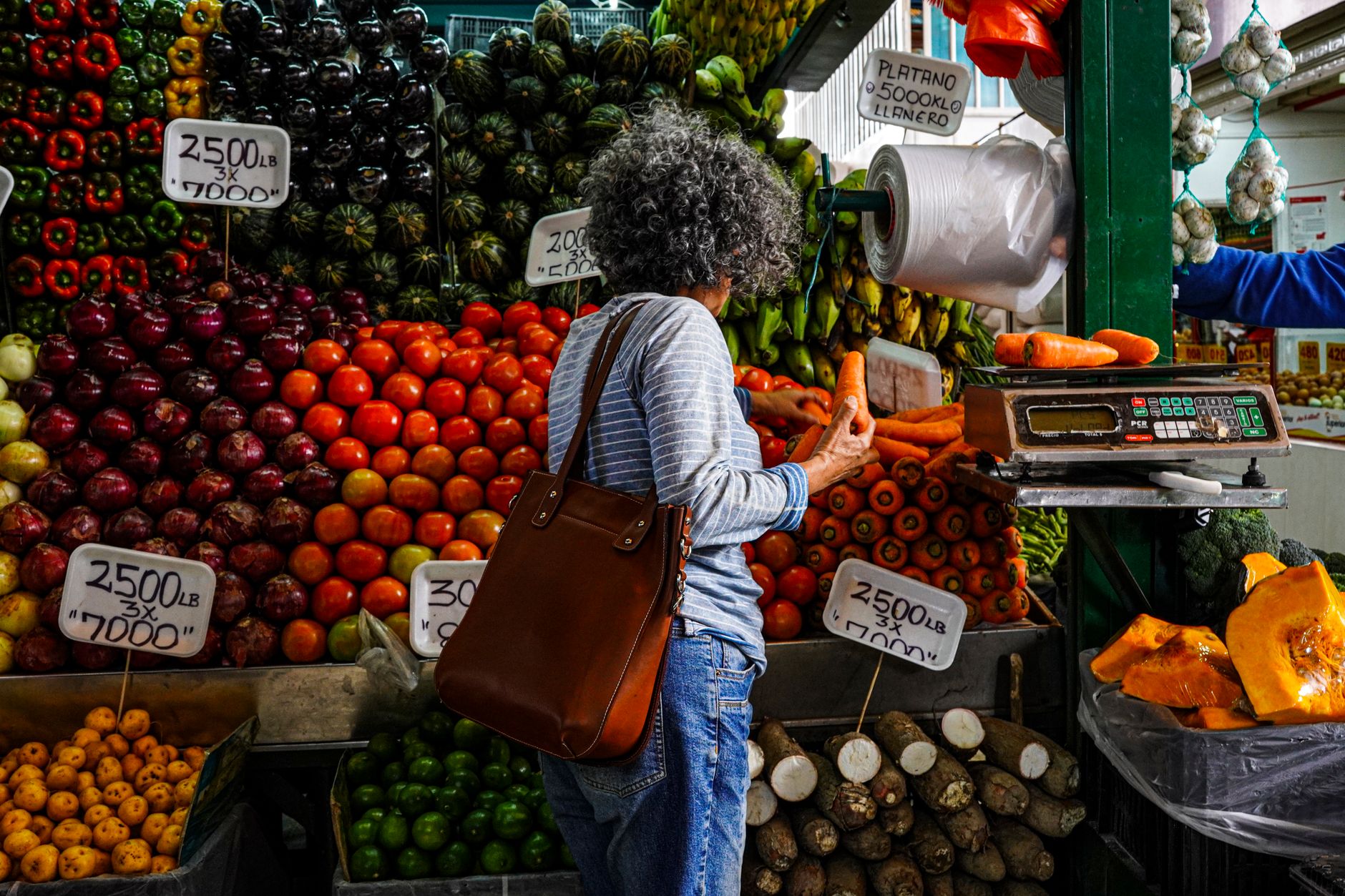 Mujer revisa alimentos frescos en un mercado de Estados Unidos